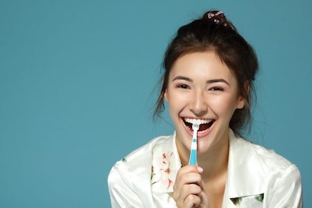 woman holding up toothbrush